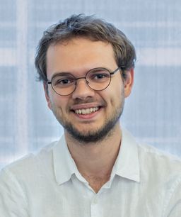 A headshot of Rayo smiling at the camera